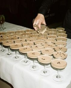 a table topped with lots of wine glasses filled with champagne being poured into them to be served