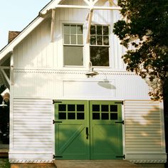 a white house with green doors and windows