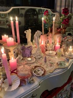 a table topped with lots of different types of candles and other things on top of it