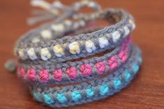 three crocheted bracelets sitting on top of a wooden table