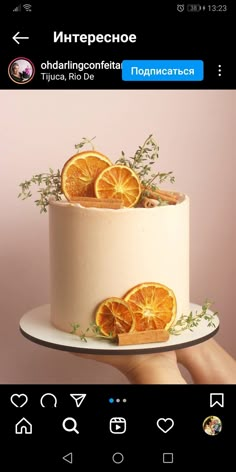 a cake with orange slices on it is being held up by someone's hand