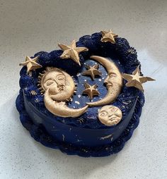 a blue cake decorated with stars and moon faces