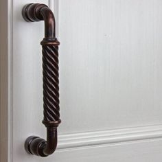 an old door handle is shown on the white door with wood trimming and rope