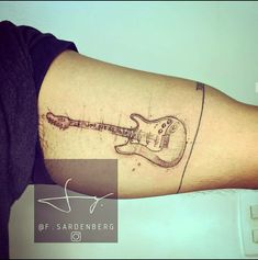 a person with a guitar tattoo on their arm