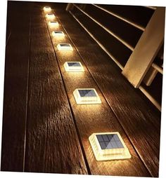 four solar powered lights are on the floor next to each other, and one is turned on