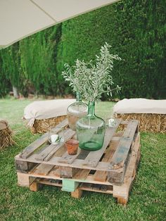 a table made out of wooden pallets with flowers in a vase on the top