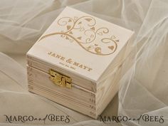 a small wooden box sitting on top of a white cloth covered bed sheet with the word thank you