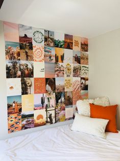 a white bed topped with lots of pillows next to a wall covered in many different pictures