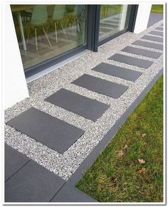 an image of a walkway made out of stones and gravel in front of a window