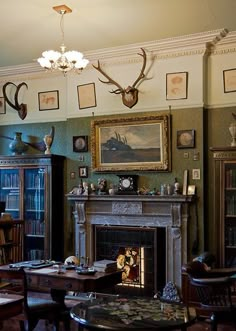 a living room filled with furniture and a fire place in front of a painting on the wall