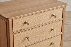 a wooden dresser with brass handles and knobs