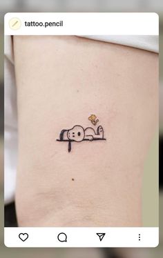 a small tattoo on the side of a woman's stomach that has a dog sleeping on it