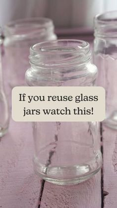 three glass jars sitting on top of a wooden table with a sign that says, if you reuse glass jars watch this