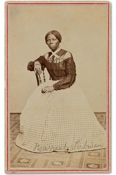 an old photo of a woman sitting on the floor wearing a dress and holding a cane