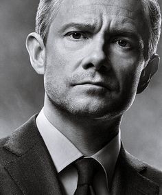 a black and white photo of a man in a suit looking at the camera with an intense look on his face