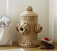 a large woven basket sitting on top of a wooden floor next to a fire hydrant