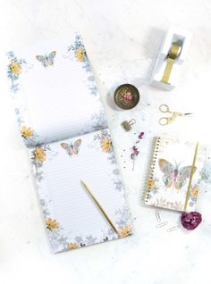 an open notebook sitting on top of a table next to some scissors and other items