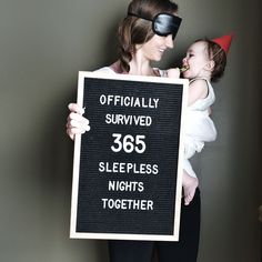 a woman holding a sign that says, officially survived 350 sleepless nights together