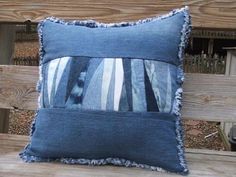 a blue striped pillow sitting on top of a wooden bench