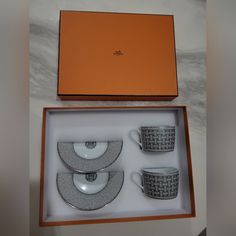 a boxed set of four coffee cups and saucers