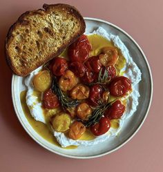 a white plate topped with bread and tomatoes