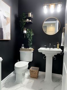 a white toilet sitting next to a sink in a bathroom under a mirror and lights