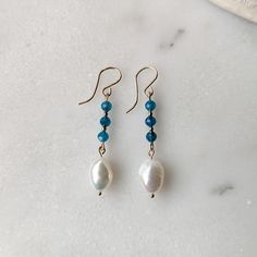 Like the clear blue waters of the ocean get lost in these Blue Apatite and Freshwater Pearl dangle earrings. The stunning faceted Blue Apatite gemstones have the most captivating transparent blue color to them. They are paired with organically shaped freshwater pearls to give you that tropical/coastal vibe. Both the Blue Apatite and Freshwater Pearls are superior AAA grade gemstones (the best you can get!) That is why the Blue Apatite has that dreamy transparent deep blue color, and the pearls h Blue Apatite Gemstone Earrings, Handmade Blue Apatite Earrings, Blue Briolette Jewelry With Pearl Drop, Blue Briolette Pearl Drop Jewelry, Elegant Turquoise Apatite Earrings, Hypoallergenic Blue Briolette Earrings, Blue Apatite Earrings Gift, Blue Apatite Earrings For Gift, Blue Faceted Long Drop Jewelry