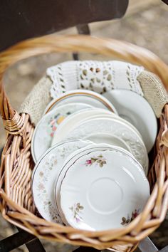 a wicker basket filled with white dishes