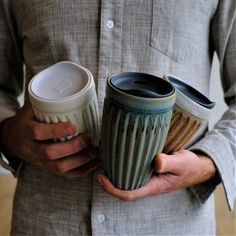 a man holding two coffee cups in his hands