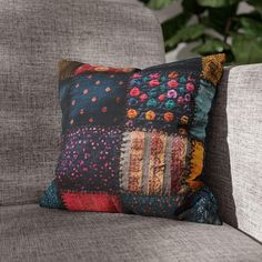 a decorative pillow sitting on top of a gray couch