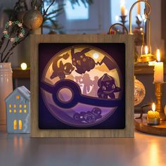 a wooden frame sitting on top of a table next to a vase with flowers and candles