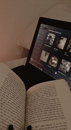 an open book sitting next to a laptop computer