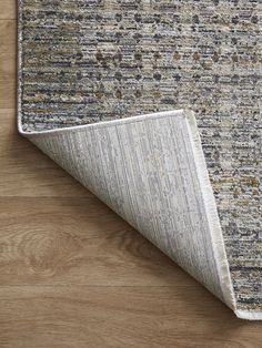 an area rug with wood flooring on top of it and a wooden floor in the background