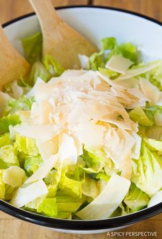 a white bowl filled with lettuce and cheese