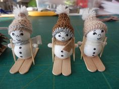 three snowmen sitting on sleds made out of wood