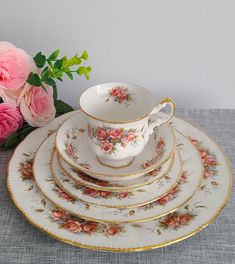 a stack of plates with pink flowers in the middle and one on each plate next to it