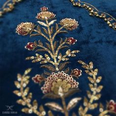 a blue velvet jacket with gold and red embroidered flowers on it's back side