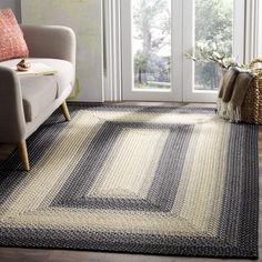 a living room area with a couch, chair and rug on the floor in front of sliding glass doors