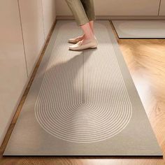 a woman standing on top of a rug in a kitchen