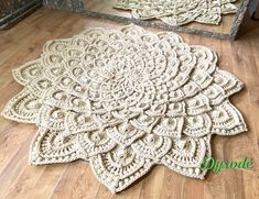 two crocheted rugs sitting on the floor next to each other in front of a mirror