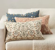 four pillows are sitting on a white couch