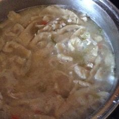 a silver bowl filled with pasta and meat