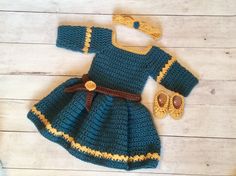 a crocheted baby dress and booties is shown on a white wooden floor