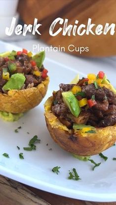 two stuffed sweet potatoes topped with meat and veggies are on a white plate