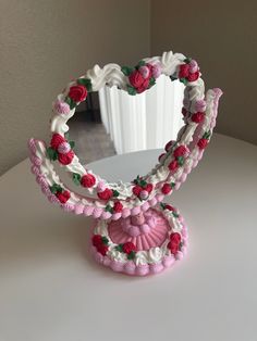 a heart shaped mirror sitting on top of a table