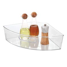 three bottles and two spoons on a glass tray with wood handles, set on a white background