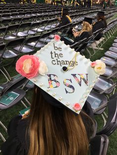 a woman wearing a graduation cap that says be the change in front of an empty stadium