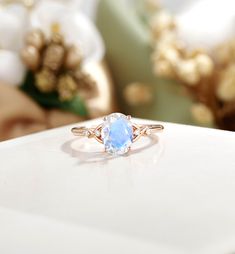 a close up of a ring with a blue stone in it on a white surface