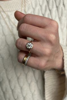 a woman's hand with two rings on top of her ring and the other one is