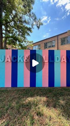 a sign that says jack and holiday in front of a building with colorful stripes on it